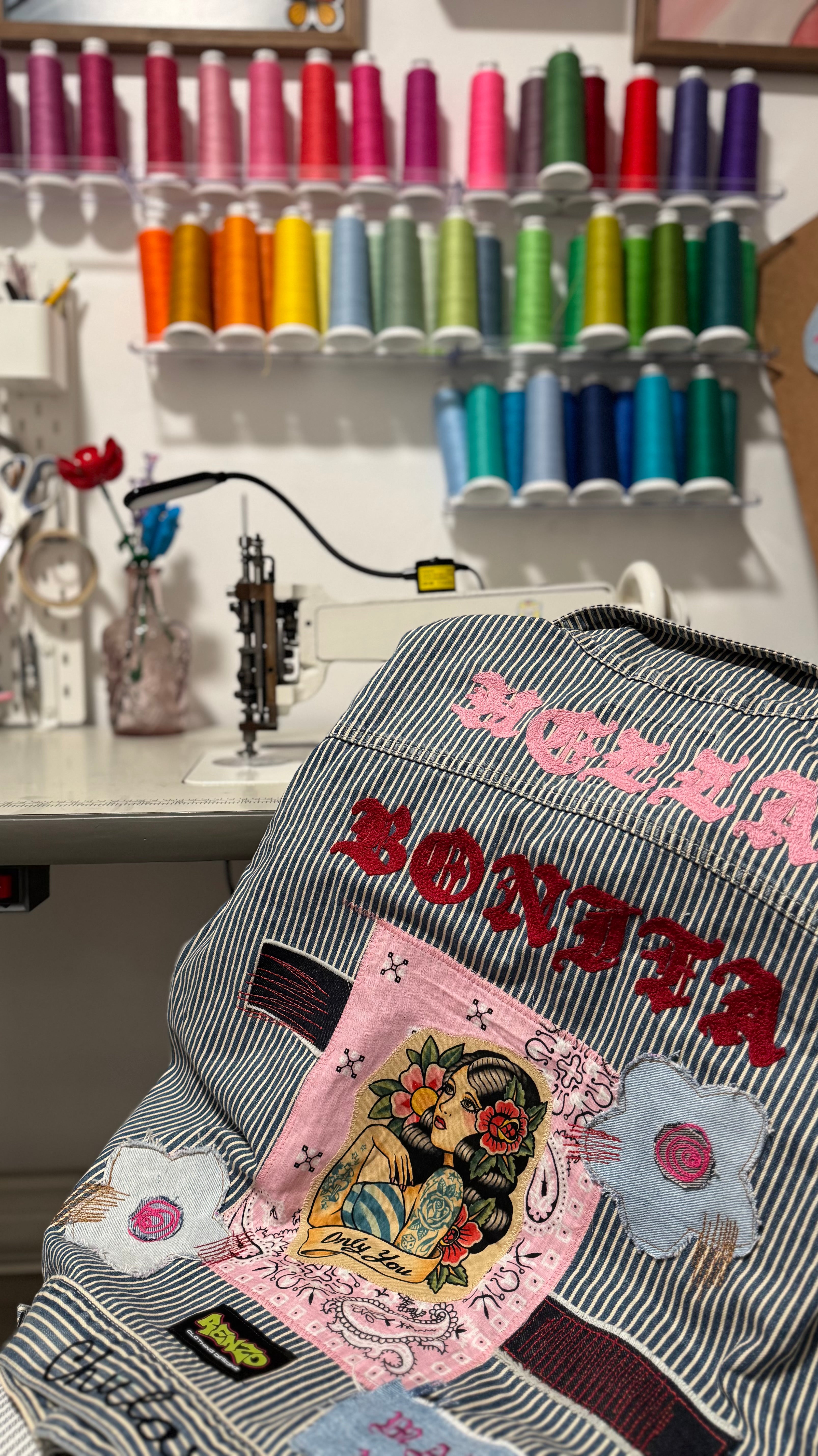 Embroidered jacket with colorful designs in a sewing room setting